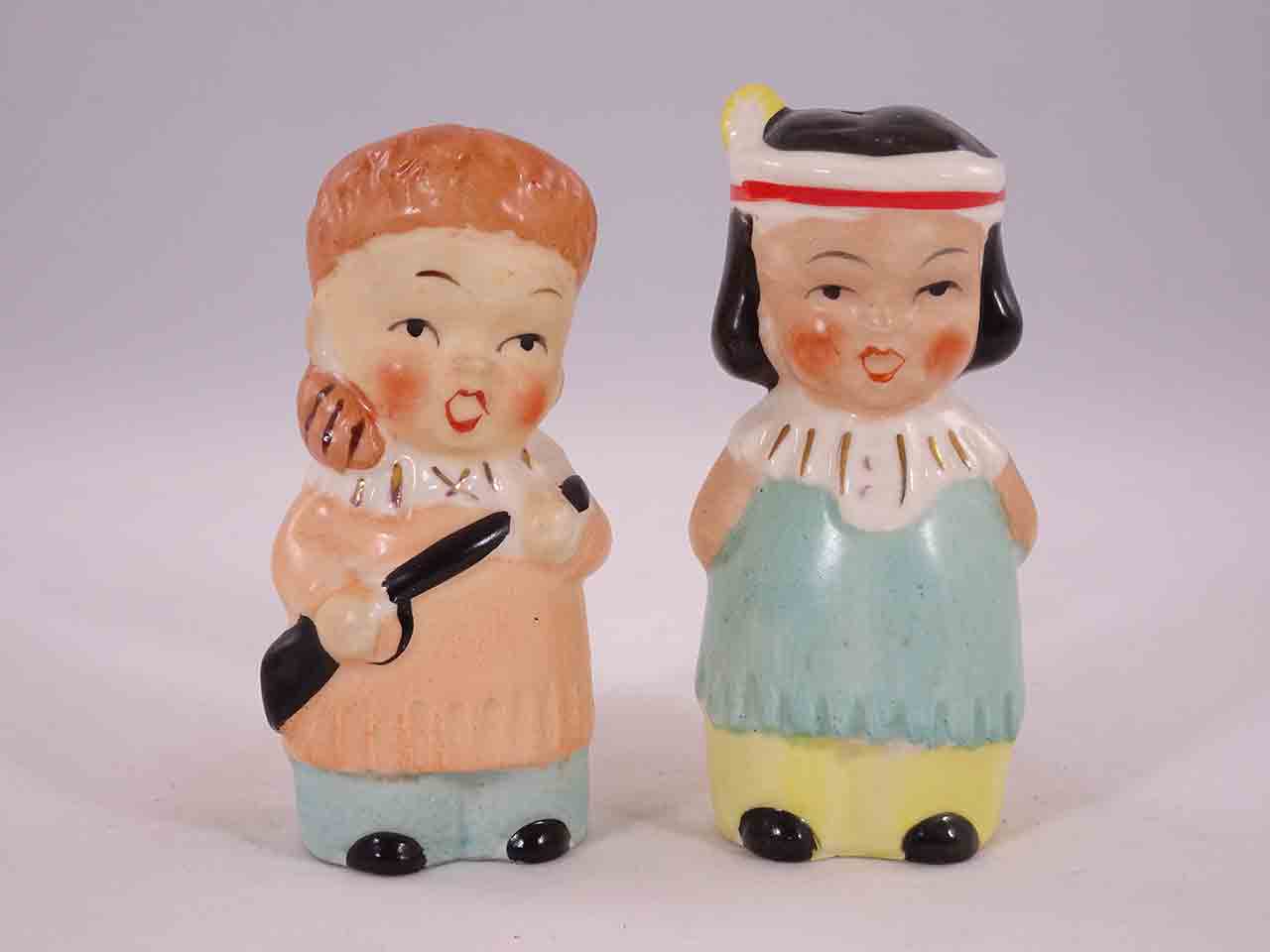 Davy Crockett-like boys carrying guns with little Native American Indian girls salt and pepper shakers